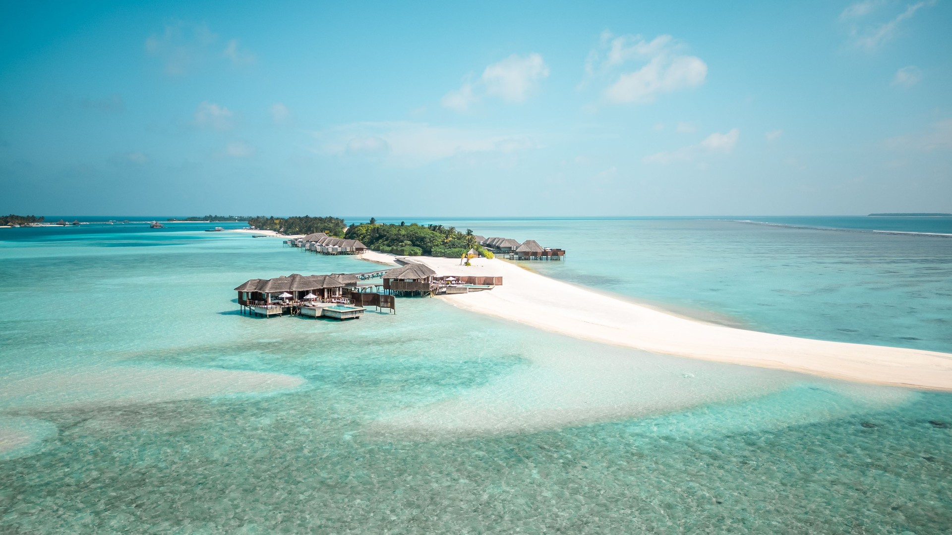 Aerial drone view of Maldives overwater villas bungalows in tropical island resort lagoon with turquoise sea and beach